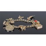 9 carat gold charm bracelet, with a selection of charms including a fish, a bible, a hat, a well,