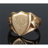 18 carat gold signet ring, the shield head with monogram, scroll shoulders, ring size O, 8.7 grams