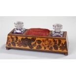 Victorian Tunbridge ware desk stand, with a central cushion flanked by glass inkwells. The shaped