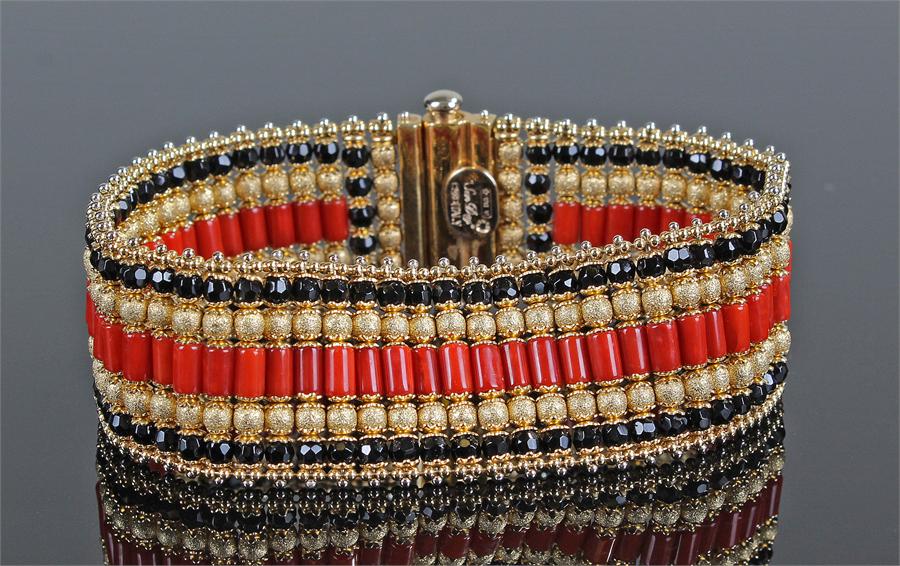 Unusual 18 carat gold and coral bracelet set in lines with central coral band, 19.5cm long, 52.5