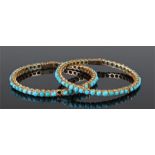Two Indian yellow metal and turquoise set bracelets both with a row of turquoise stones in yellow