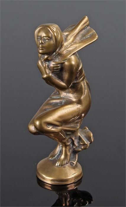 Early 20th Century car mascot in brass of a lady crouching wind swept, 13cm high
