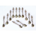 Set of twelve silver spoons, each spoon with a figure holding a crowned shield, C scroll stem and
