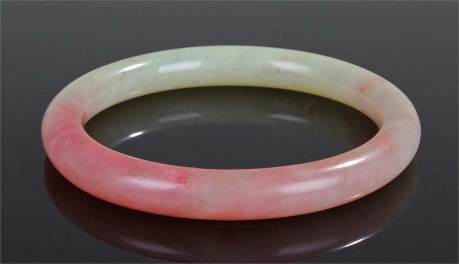 Jade bangle, from pale green to pink in colour, 8cm wide