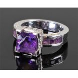 White metal amethyst and diamond set ring. The central amethyst flanked by a further six amethyst