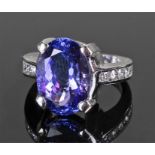 14 carat gold tanzanite and diamond set ring. The central oval tanzanite flanked with five