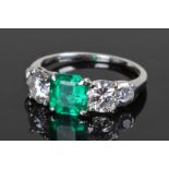 Platinum emerald and diamond set ring, the central Colombian step cut emerald at 1.25 carats flanked