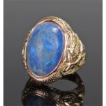 Yellow metal blue opal ring, the domed opal set within a twisted dragon shank, ring size L