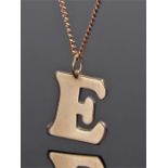 9 carat gold "E" pendant on chain, the pendant in the form of a capital E suspended upon a curb link