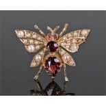 9 carat gold pearl set butterfly brooch, the pearl set rings with garnet back, 27mm wide