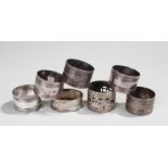 Napkin rings, to include a set of five, a silver example and another, (7)