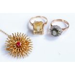 Yellow metal star burst brooch, with central red stone, together with two yellow metal rings, (3)