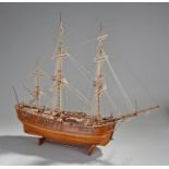 Model of a three mast ship, fully rigged, canons on the deck, raised on a shaped base, 78cm long