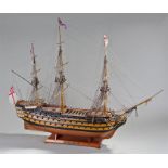 Large model of HMS Victory, sails down, fully rigged, cannons to each side, raised on a shaped base,