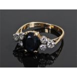 18 carat gold sapphire and diamond ring, the central sapphire flanked with thrEe diamonds to each