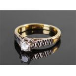 18 carat gold diamond ring, the diamond at approximately 0.20 carat flanked by platinum zigzag