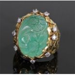 Unusual carved emerald and diamond set ring, the emerald at 20mm in length carved with two