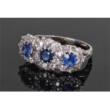 Sapphire and diamond set white gold ring, set with three sapphires surrounded by diamonds, ring size