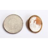 Carved shell cameo brooch, showing two ladies in a country scene and set in a gold plated frame,