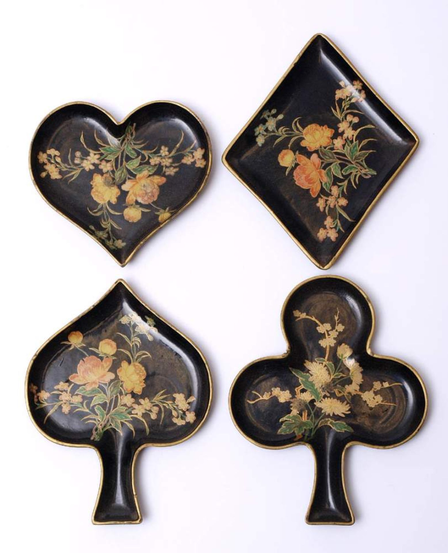 Vier Spielmarkenbehälter, um 1900In Form von Kreuz, Pik, As bzw. Herz. Gelacktes Papier mit
