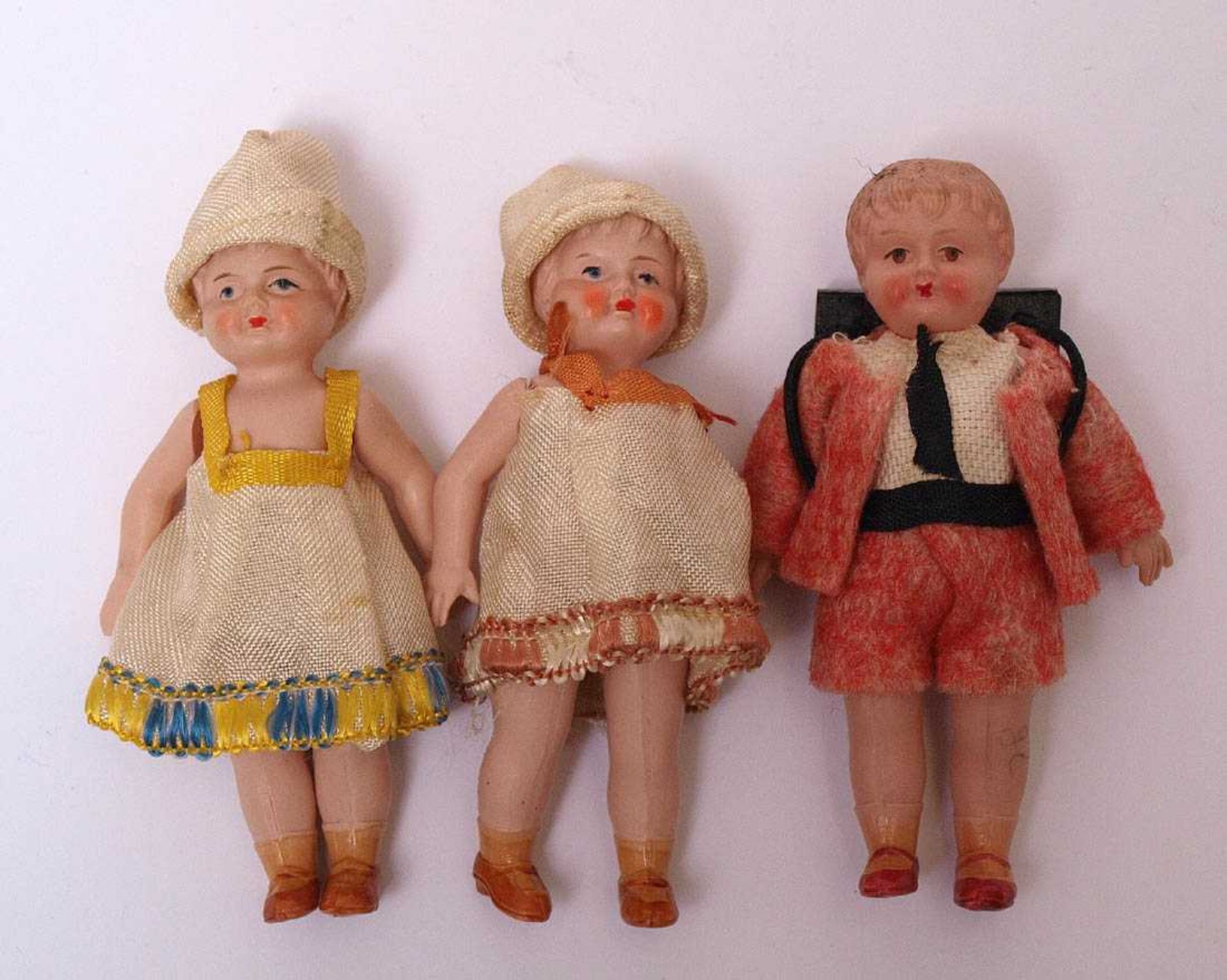 Drei Puppenstubenpuppen, wohl Buschow & BeckZwei Mädchen ein Junge im Anzug mit Schulranzen.