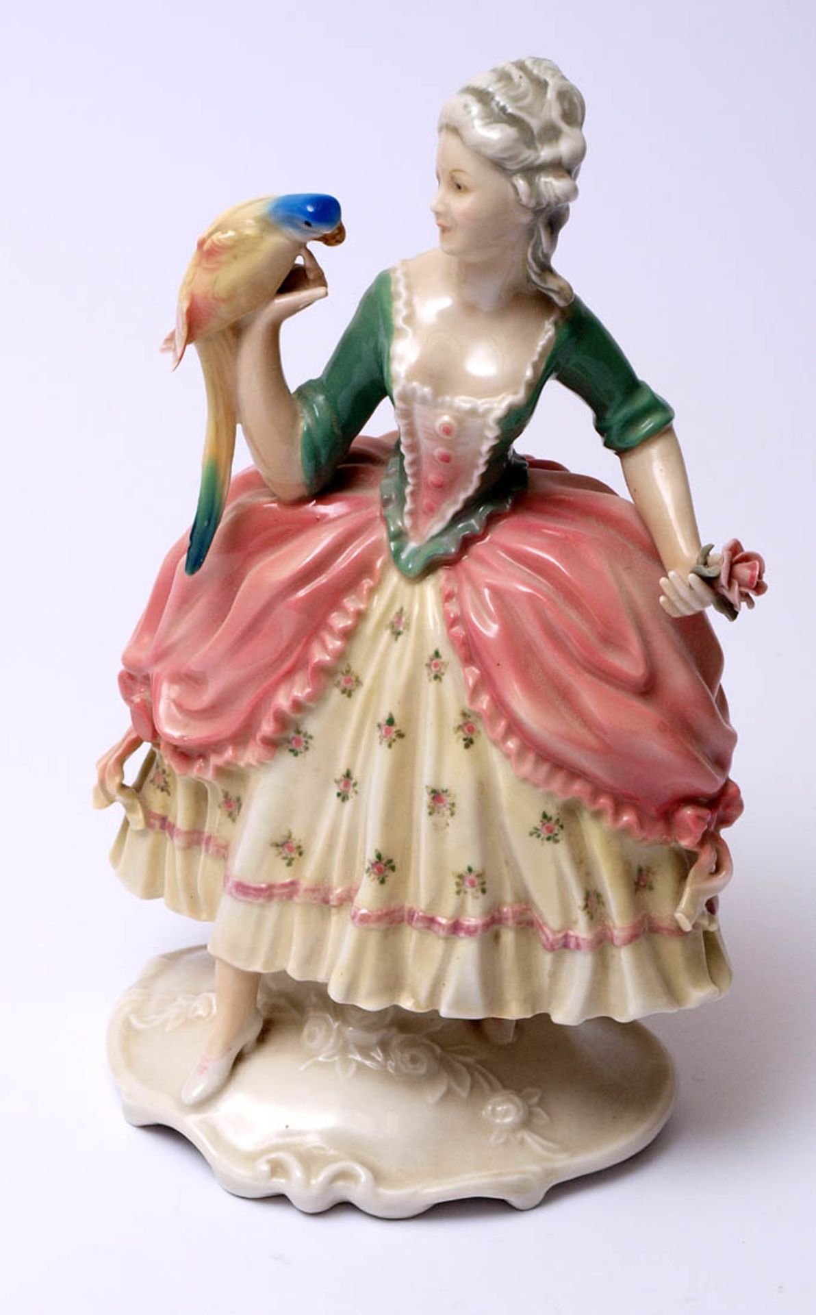 Figurine, Ens Auf ovalem reliefiertem Sockel Dame in Krinolinenkleid, in der linken Hand eine Rose