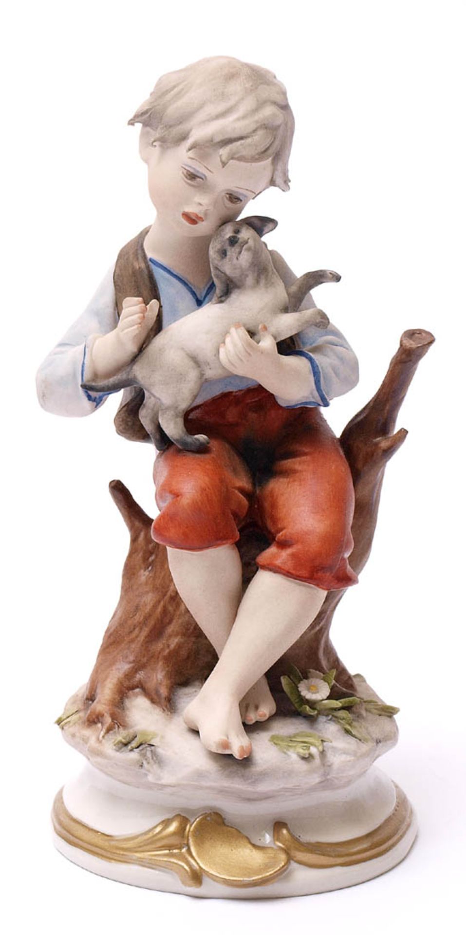 Figurine Auf einem Baumstumpf sitzender Knabe, auf dem Schoss einen kleinen Hund haltend.