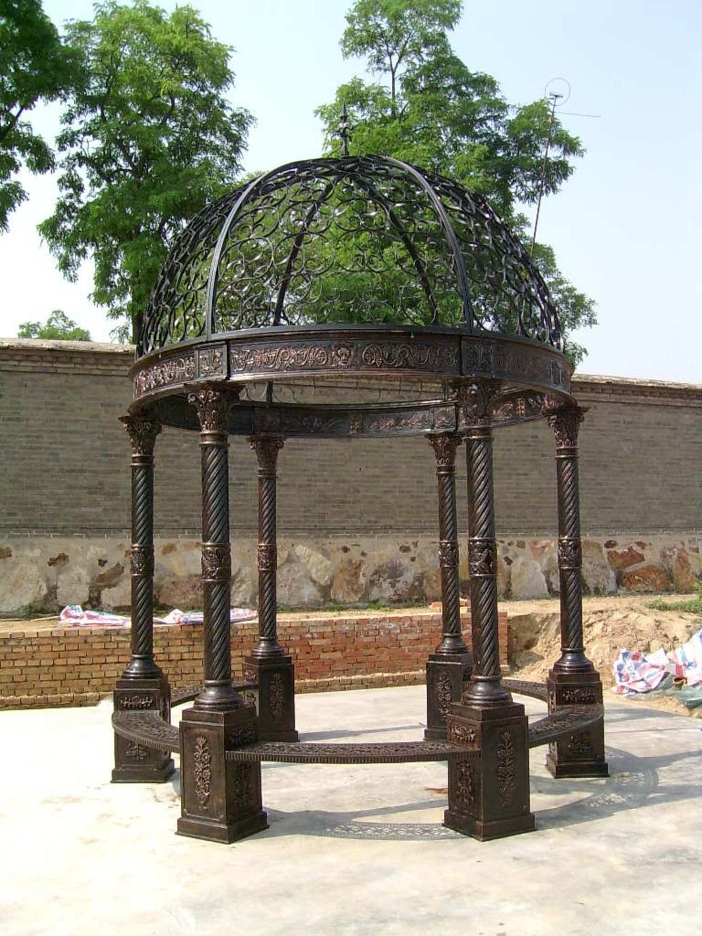 CAST IRON ORNATE GAZEBO WITH CORINTHIUM COLUMNS AND ORNATE WROUGHT IRON ROOF - 2.4M DIAMETER. UNUSED