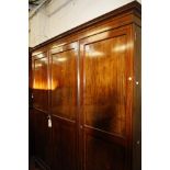 A mahogany and inlaid triple wardrobe with a single and double cupboard enclosing hanging space on