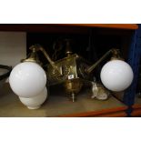 An Arts & Crafts brass electrolier with white globe shades