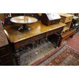 A Victorian oak hall table with a carved back and frieze on bobbin turned legs 137cm wide