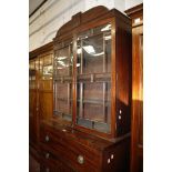 A George IV mahogany secretaire-bookcase, circa 1825, the break arch cornice above a pair of panel