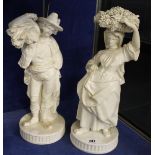 A pair of white glazed pottery harvest figures, 34cm and 38cm high