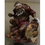 A Chinese stoneware figure of a fisherman, glazed in red and brown, 23.5cm high