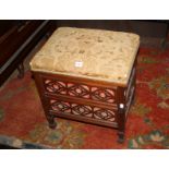 A late Victorian mahogany piano stool with a hinged upholstered seat and fret decoration to the