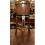 An Arts and Crafts style oak and brass bound jardiniere on stand with stylized pierced decoration