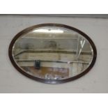 An Edwardian mahogany oval wall mirror 95cm wide together with a gilt decorated example and