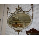 An 18th Century style gilt and painted oval wall mirror with central urn crest flanked by swags 97 x