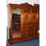 A late Victorian walnut bedroom suite to include a wardrobe enclosing hanging space and linen slides