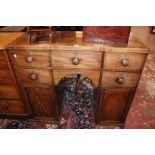 A late Regency brass inlaid sideboard with five short drawers and cupboards 111cm wide