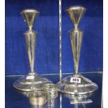 A pair of 20th Century silver coloured metal mounted candlesticks, 25.5cm high and two silver napkin