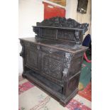A late Victorian carved oak sideboard with a superstructure, two drawers and cupboards below 153cm