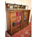 A Victorian walnut and ebonised open bookcase with a mirrored back, spiral twist columns and open