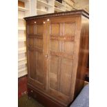 An oak wardrobe with dentil cornice and panelled doors with drawer below 169cm high, 108cm wide