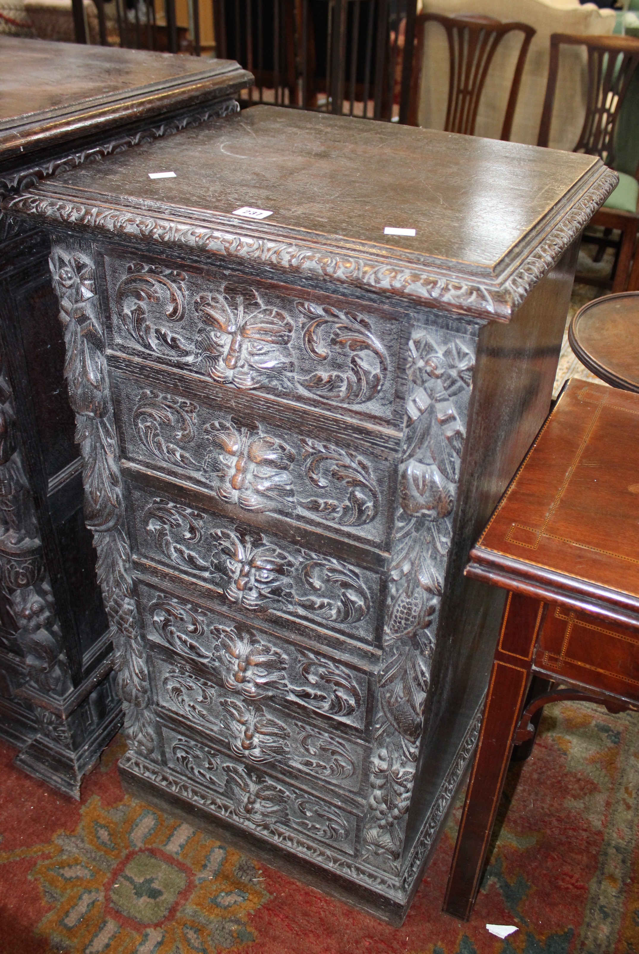 A late Victorian carved oak chest with six drawers with lion mask handles 54cm wide