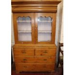 A pine kitchen cupboard on chest, the upper part enclosing painted shelves and three drawers below