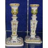 A pair of faience candlesticks, floral decorated, 23cm high