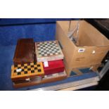 A wooden chess set, other chess sets, boxes and boards
