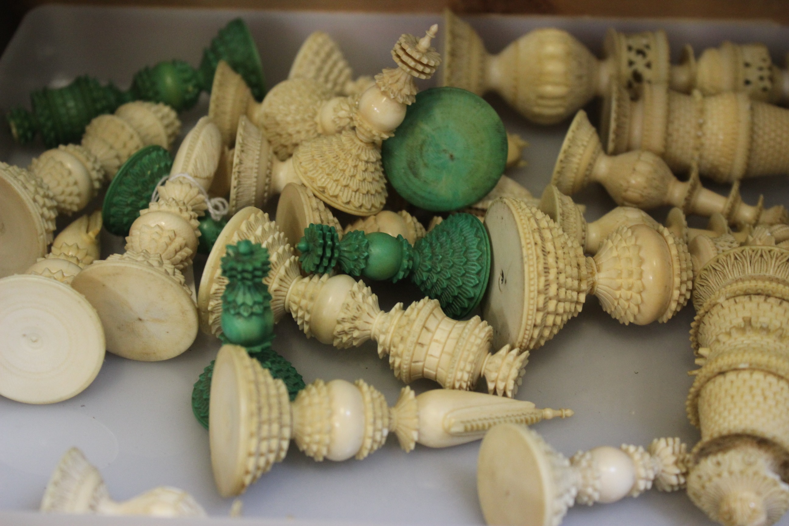 A quantity of 19th Century Anglo - Indian stained ivory chess pieces, heavily ornate, a mix of two