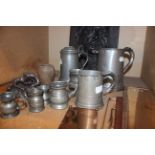 A quantity of pewter measures, door plaques and other items